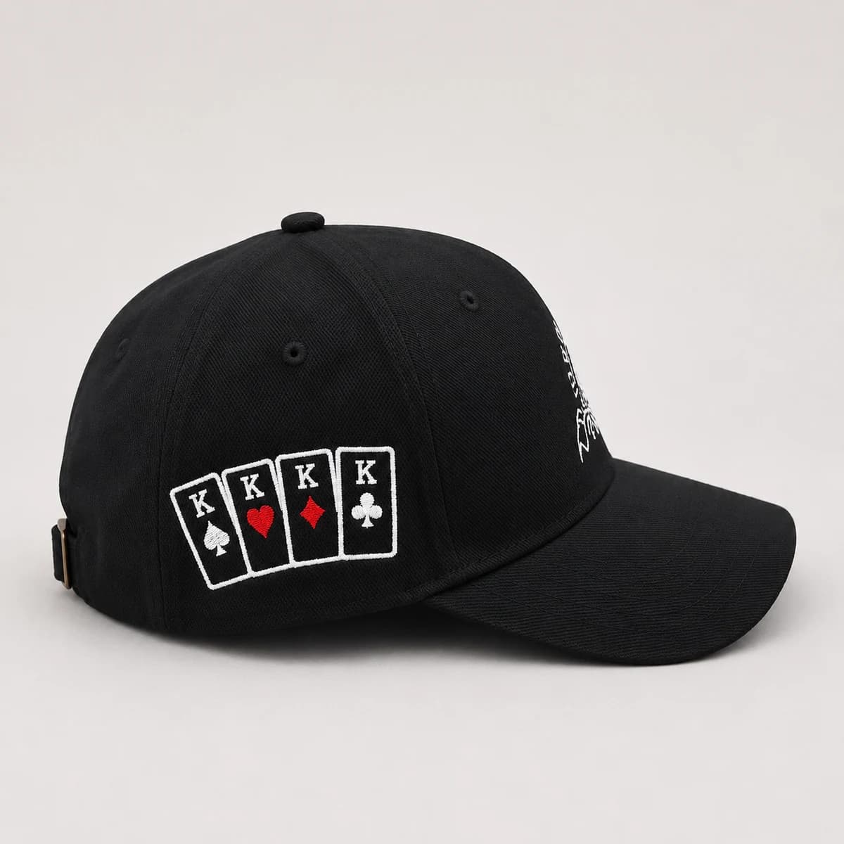Côté d'une casquette noire avec un carré de rois brodé en blanc et rouge