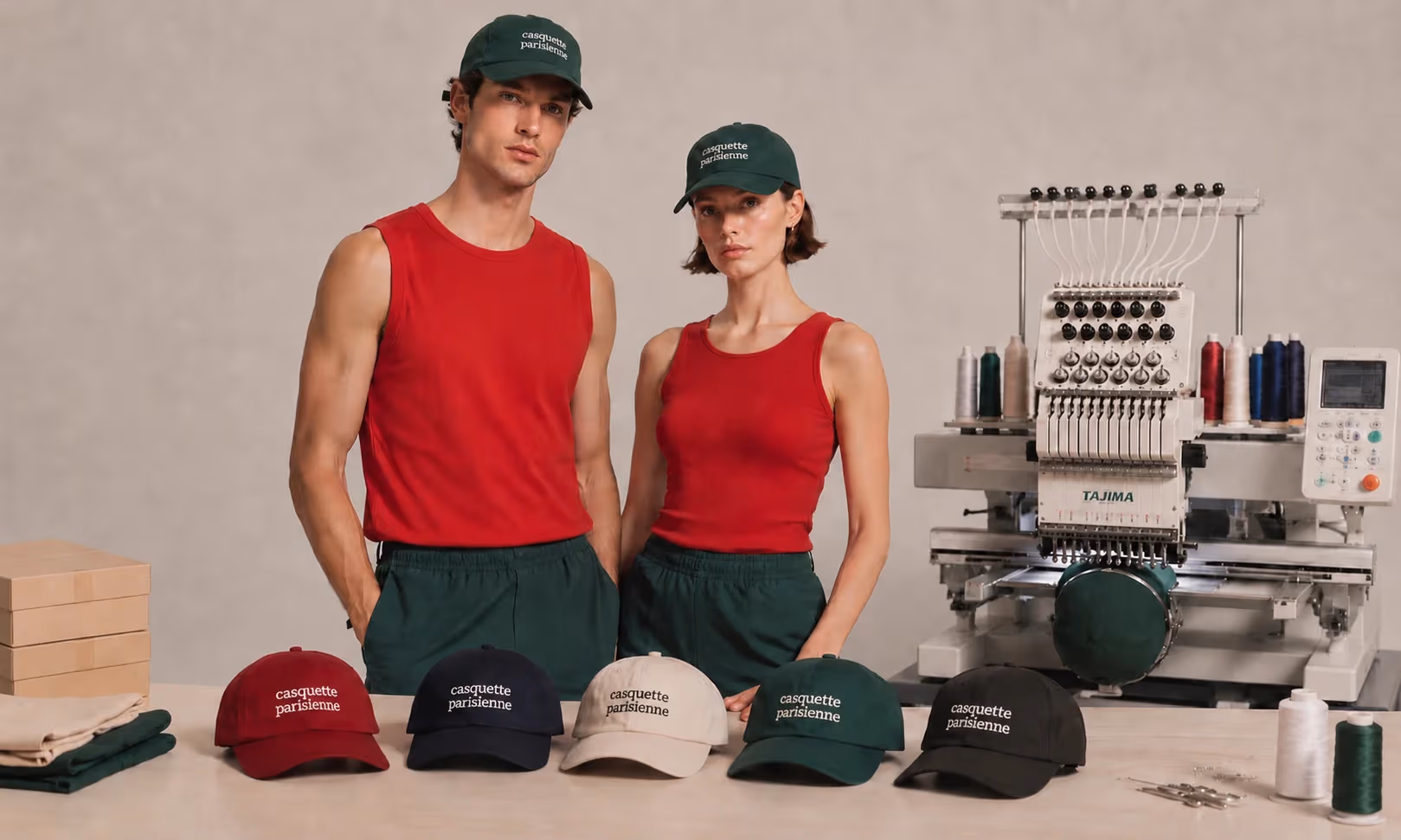 Casquettes brodées Casquette Parisienne en cinq coloris et machine de broderie à l'atelier, portées par deux personnes